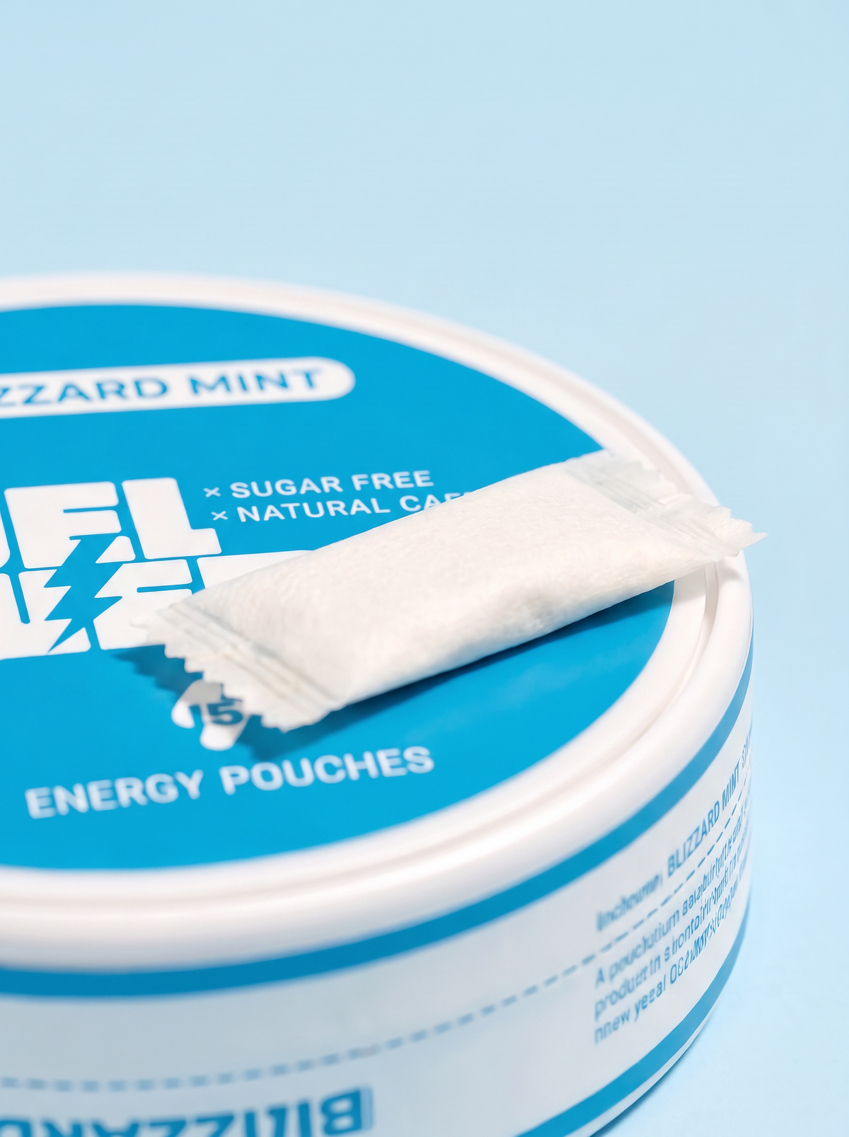 Close-up of a single FUEL Energy Blizzard Mint caffeine pouch resting on the tin lid