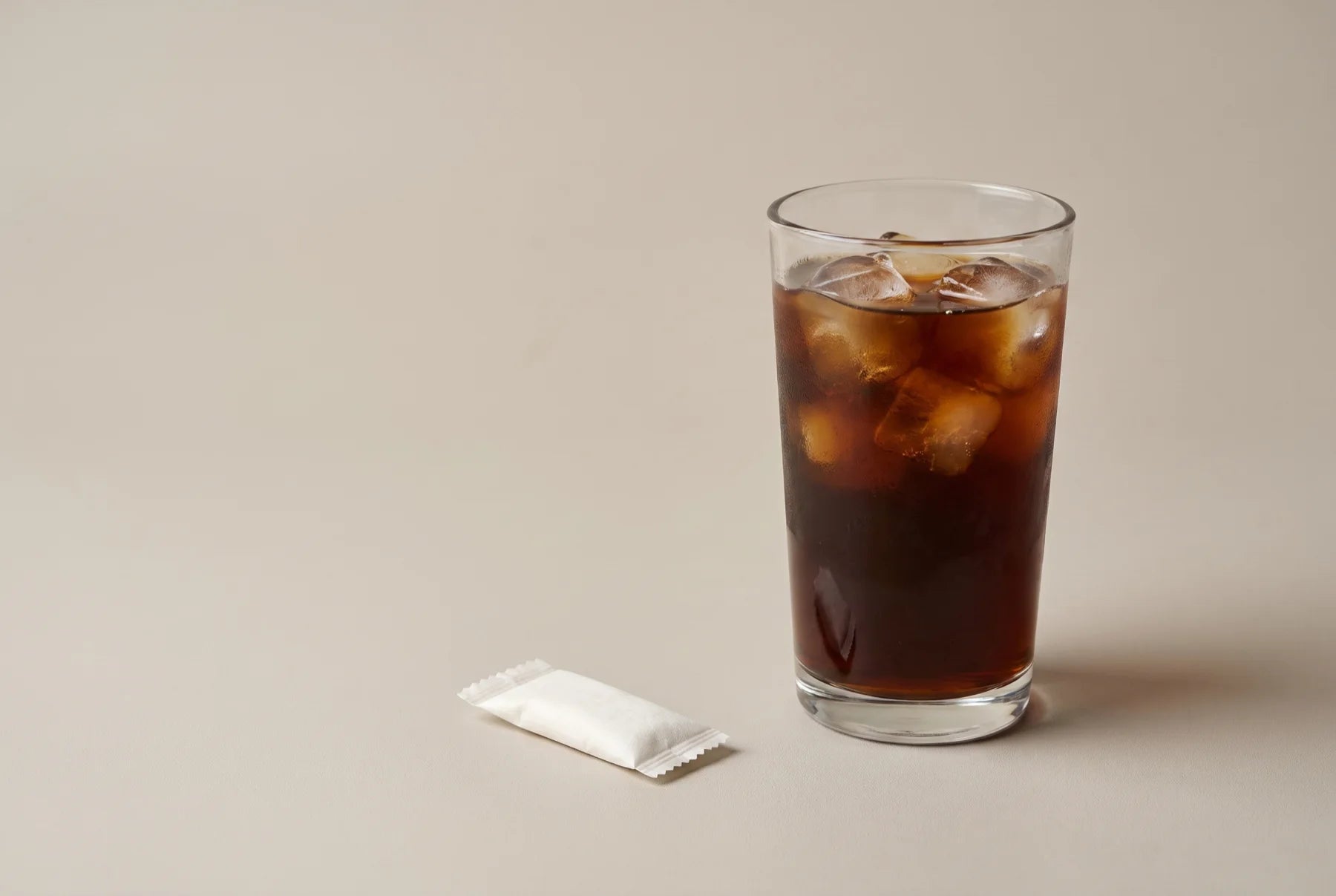 One small FUEL pouch beside a full iced coffee — the same caffeine hit